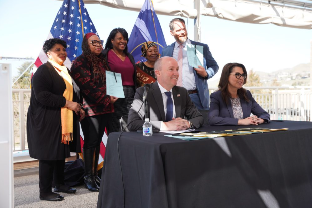 A group of people, including Utah's Governor and Lieutenant Governor, gathering for the signing of Juneteenth National Freedom Day as an observed holiday in Utah.